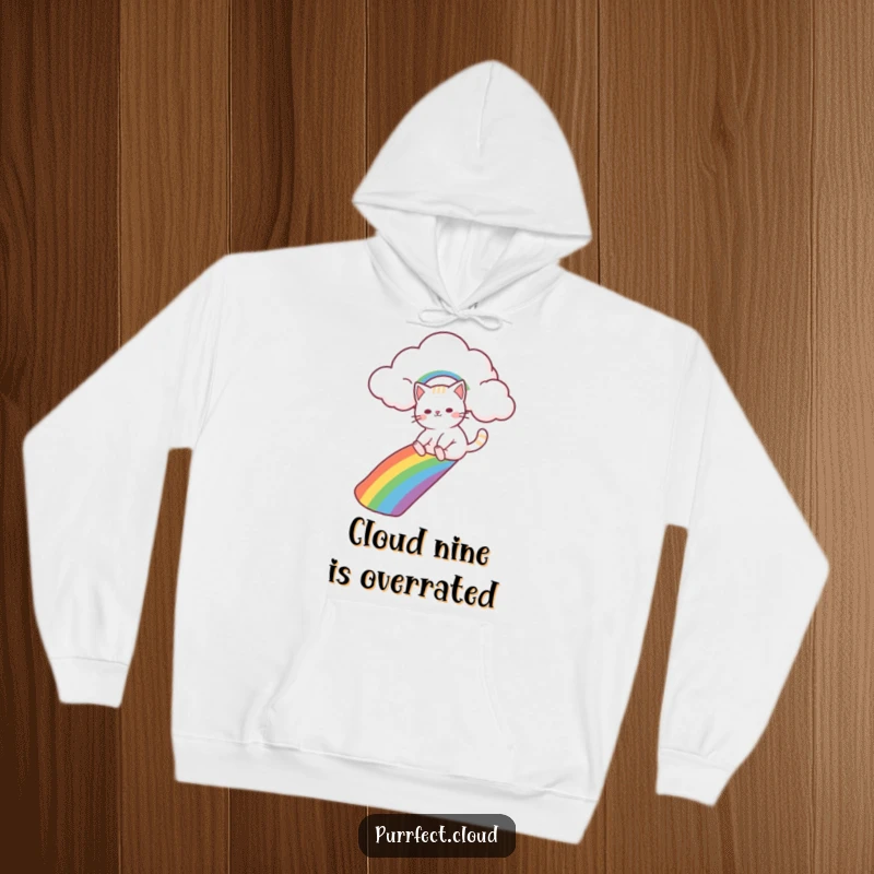 Funny cat character slides down a bright rainbow from a cloud, featured on a soft and warm hoodie for ultimate comfort.